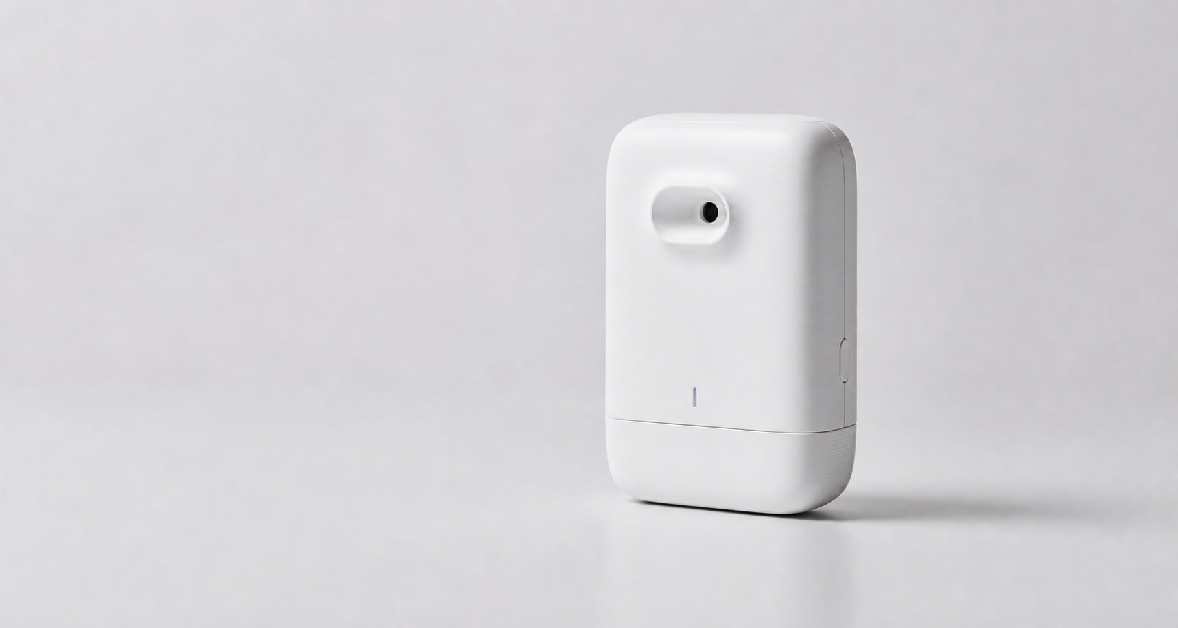 Compact white olfactory sensing device photographed in a minimal studio setting
